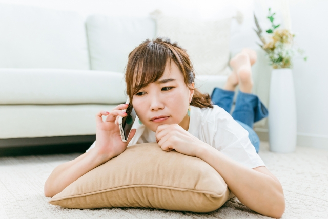 迷惑そうに電話する女性