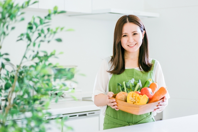 キッチンで食材を持つ女性